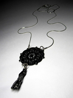Pendant with a meteorite and lace