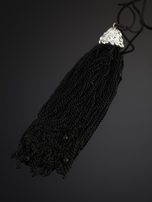 Decoration brush of black metal chains on a metal cord