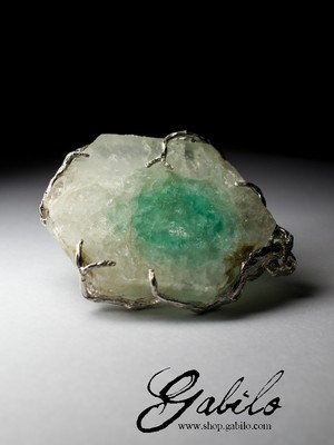 A large pendant with an emerald in beryl
